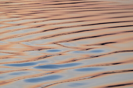 Canada, Nunavut, Northwest Passage, Bellot Strait at sunrise. Water detail reflecting dawn colors.