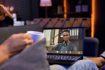 African american adult attending a virtual workshop lesson via video call, participating at the discussion in his cozy home. Young person joining video conference interactive learning session.