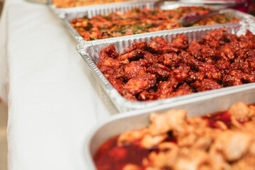 Spicy Korean fried chicken in buffet-style foil tray with copy space 