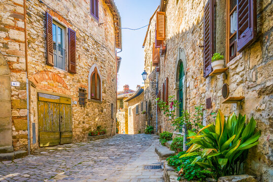 Fototapeta Greve in Chianti, Tuscany, Italy. ancient buildings on cobbled street showing stonework walls.