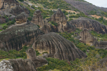 Detail view of landscape with eroded rocks of Meteora rock formations with green grass at spring time, Kalambaka, Thessaly, Greece
