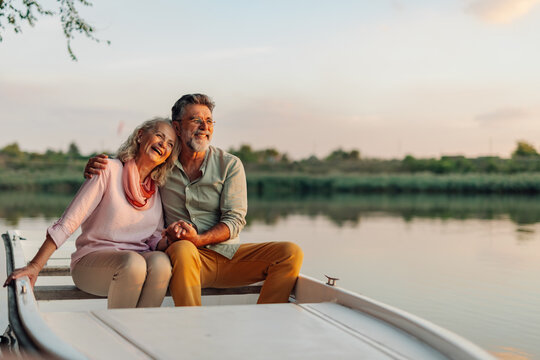 Happy senior couple enjoying a romantic boat trip at sunset