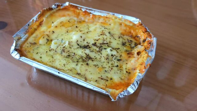 Bolognese lasagna in an aluminum lunch box.
