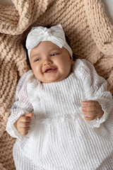 Adorable baby girl smiling in a white lace dress