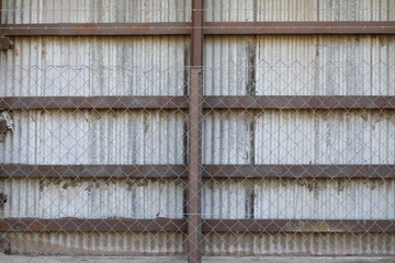 Pared de chapas del cobertizo del ferrocarril, esta apuntalado por hierros de acero y maderas por...