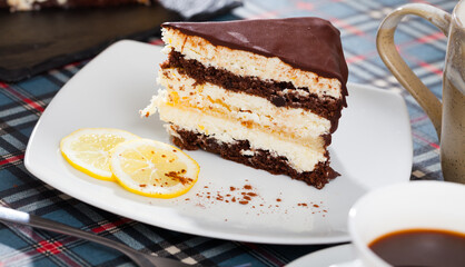 Piece of lemon-chocolate cake served with slices of lemon