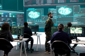 Government army hackers engaged in hybrid warfare strategies in agency office. Personnel using...