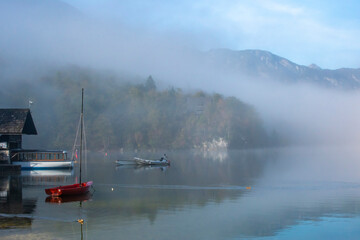 Slovenia, Lake Bohinj. Lake boats on foggy morning.