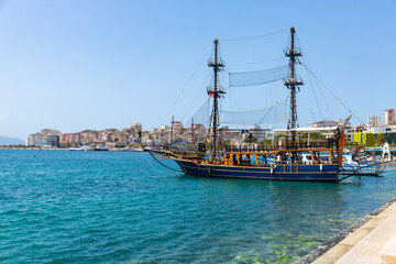 View of vintage wooden sailboats moored in harbor of coastal tourist city of Sarande on Ionian Sea...