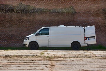 White van in front of a brick wall