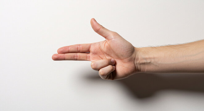 Finger Gun Gesture: A hand forms the iconic finger gun gesture, a symbol of playful intent. The gesture, crafted with precision, signifies a whimsical approach to an everyday situation.
