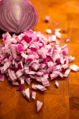 close-up of chopped red onion on a wooden cutting board in warm lighting 
