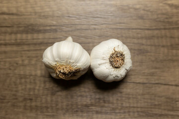 close-up of two white garlic bulbs against a wooden background