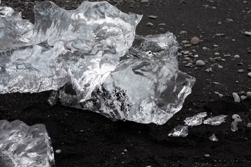 close-up of glacier ice on a black sand beach in Iceland melting in the sand