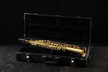 Jazz. Golden saxophone in case on black textured table