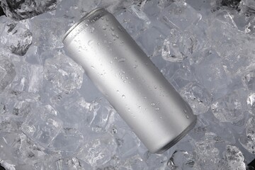 Refreshing drink in can on ice cubes, top view