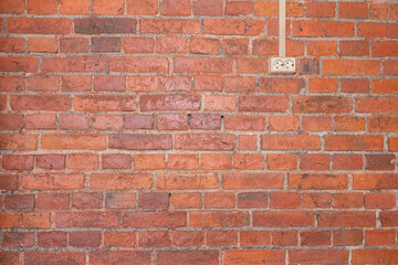 New charging station for electric car on brick wall at home, charging pillar with copy space