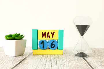 Vintage photo, May 16th. Date of 16 May on wooden cube calendar, copy space for text on board