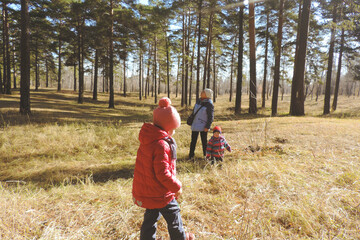 Grandmother with two granddaughters in the state park or forest. Happy family. Children wearing...