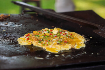 Egg martabak dough cooked in a large skillet.
