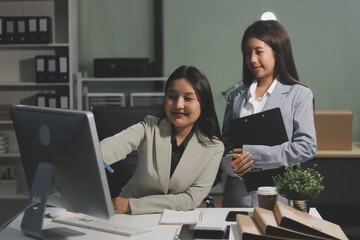 Asian Businesswoman Using laptop computer and working at office with calculator document on desk, doing planning analyzing the financial report, business plan investment, finance analysis concept.