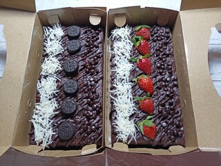Assorted brownies topped with strawberries oreos cheese and almond slices