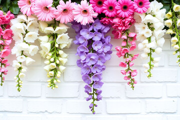 white brick wall with pink and purple flowers on it