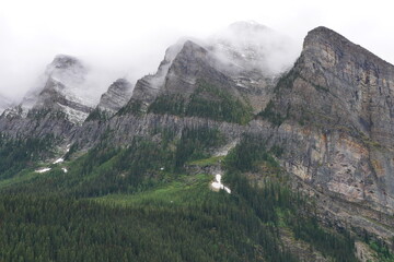 Dramatic Snow-Capped Peaks of the Canadian Rockies in Summer Fog, Lake Louise, Alberta, Canada