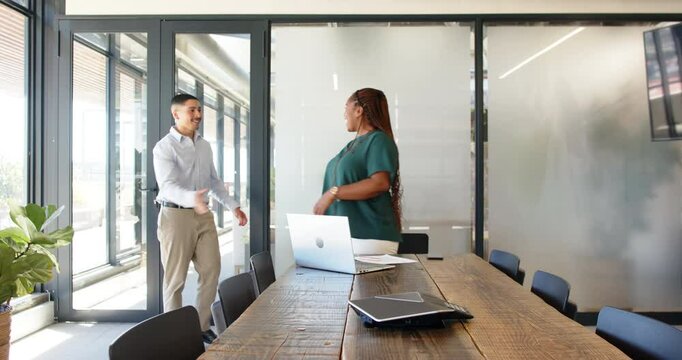 Diverse coworkers signing contract at modern office with laptop, wooden table and documents