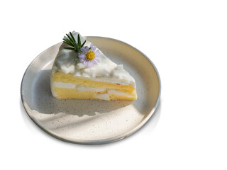 top view Coconut cake decorated with flowers and green leaves on a ceramic plate on white background, fruit, food, copy space