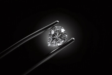 pear shaped diamond being held by tweezers