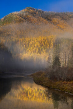 Foggy autumn sunrise on McDonald Creek and Apgar Mountain in Glacier National Park, Montana, USA