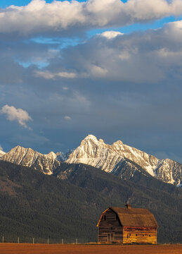Old wooden barn and Mission Mountains near Pablo, Montana, USA.