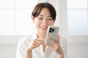 笑顔でスマホを操作する女性
