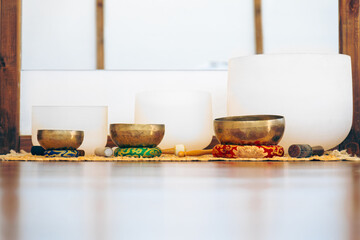 A row of four bowls, each with a different color, are sitting on a rug