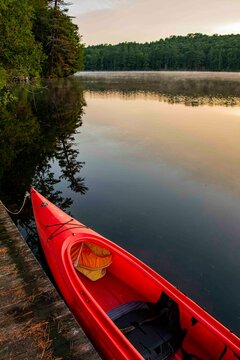 USA, New York. Adirondack Park, Saranac Lake, Hoel Pond, canoe at boathouse dock.