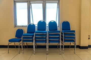 Stack of Blue Chairs Indoor Near Window Ready for Event