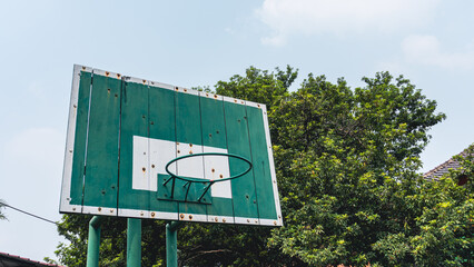 Green and White Basketball Hoop with Trees