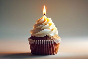 a cupcake adorned with creamy white frosting and a glowing candle