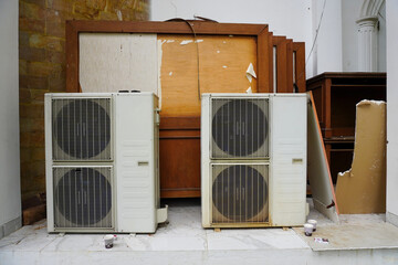 Two Carrier Air Conditioners Outdoors with Wood Debris and Furniture