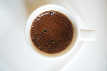 urkish Coffee served in a white cup with a rich, foamy top