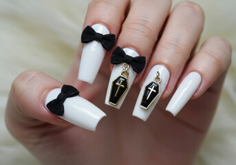 Woman's hand: white nails with black bows, holding a vibrant red rose.