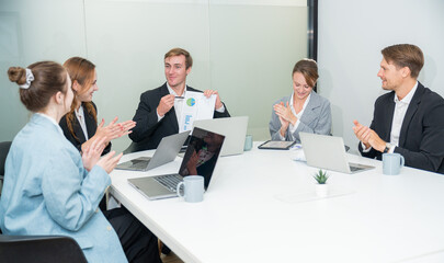 Fototapeta premium Team celebrates project success during a meeting at a modern office in the afternoon