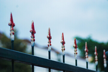 Close up, Iron fence with sharp red edges, building perimeter fence with sharp edges, carvings and...