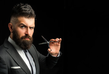 Barber using scissor to trim beard. Scissor in barbers hand shaping beard. Beard grooming done by...