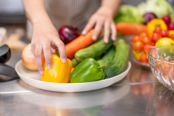 Hands of Chef Arranging Fresh Vegetables in a Professional Kitchen