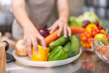 Hands of Chef Arranging Fresh Vegetables in a Professional Kitchen