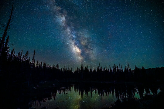 USA, Wyoming, Medicine Bow National Forest. Milky Way reflects in lake at night.