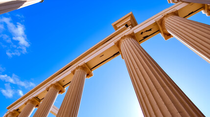 Classical Columns and Sky: Majestic ionic columns frame a vibrant blue sky, creating a serene and timeless image evoking strength, history, and architectural grandeur.