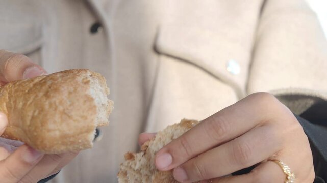 person breaking freshly baked bread 
